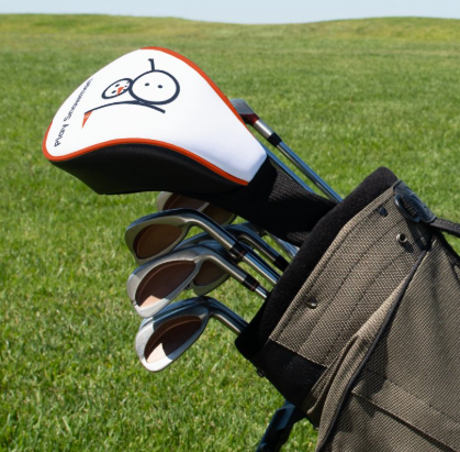 White Play Snowman driver headcover on a golf bag on the course